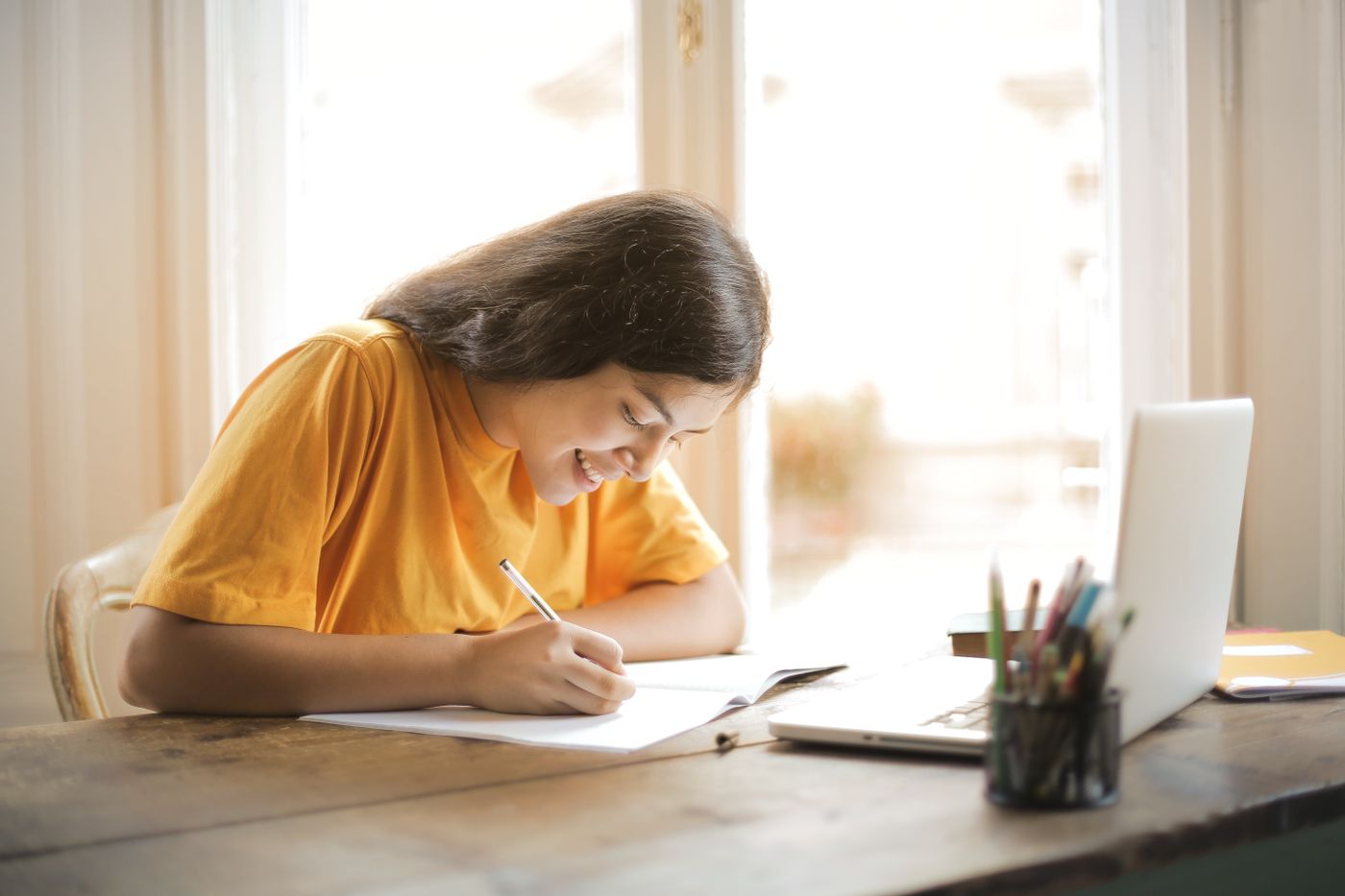 Student studying with a notebook and laptop